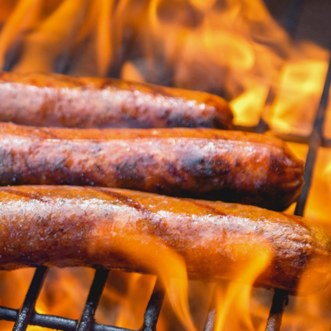 HOT DOGS ON GRILL WITH RED HOT FLAMES