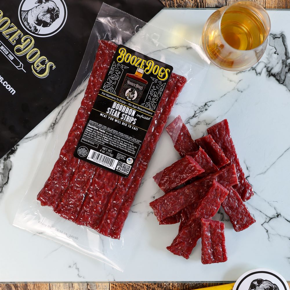 4 OZ PACK OF BOURBON INFUSED JERKY STYLE STEAK STRIPS WITH CUT PIECES TO THE