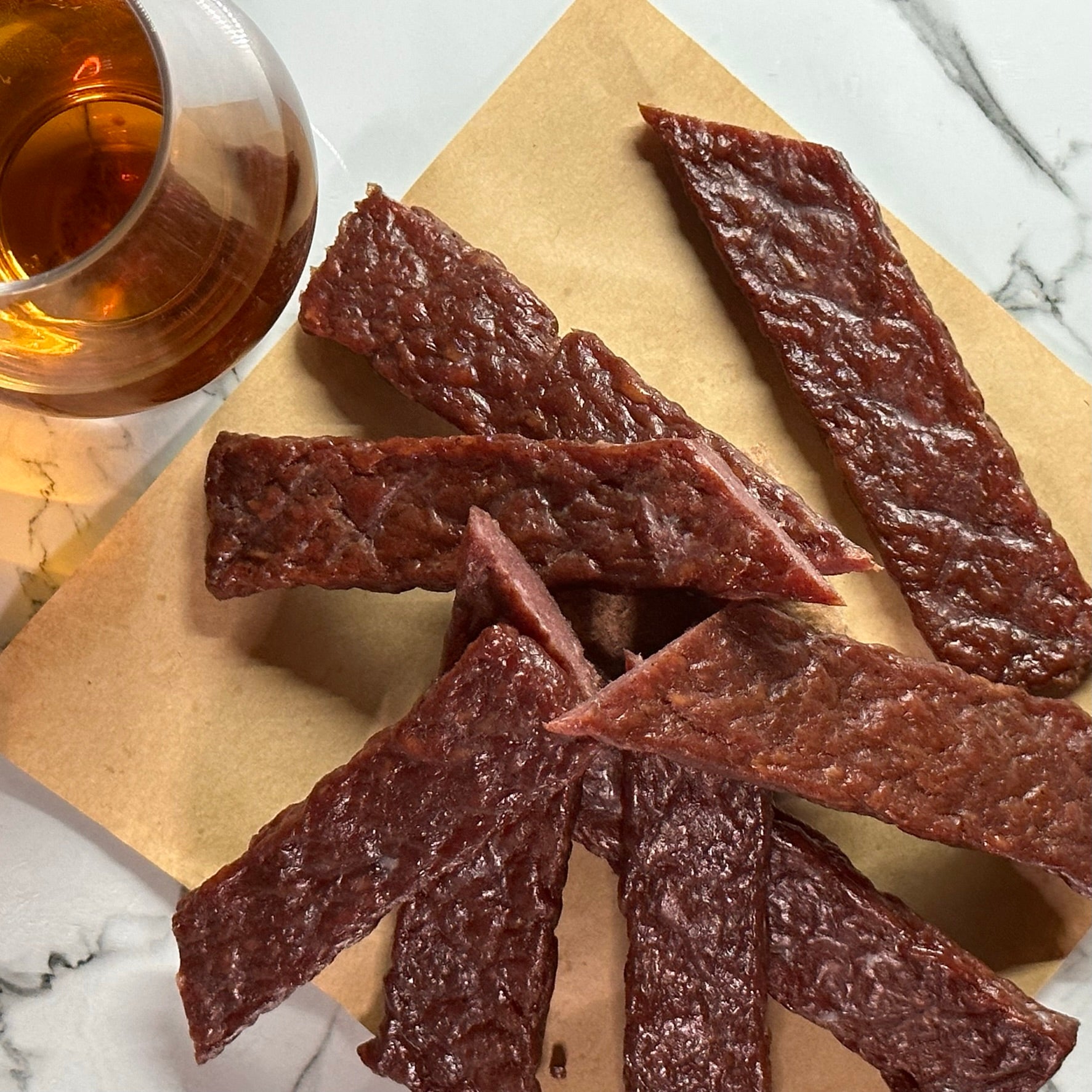 CUT PIECES OF BOURBON INFUSED JERKY STYLE STEAK STRIPS
