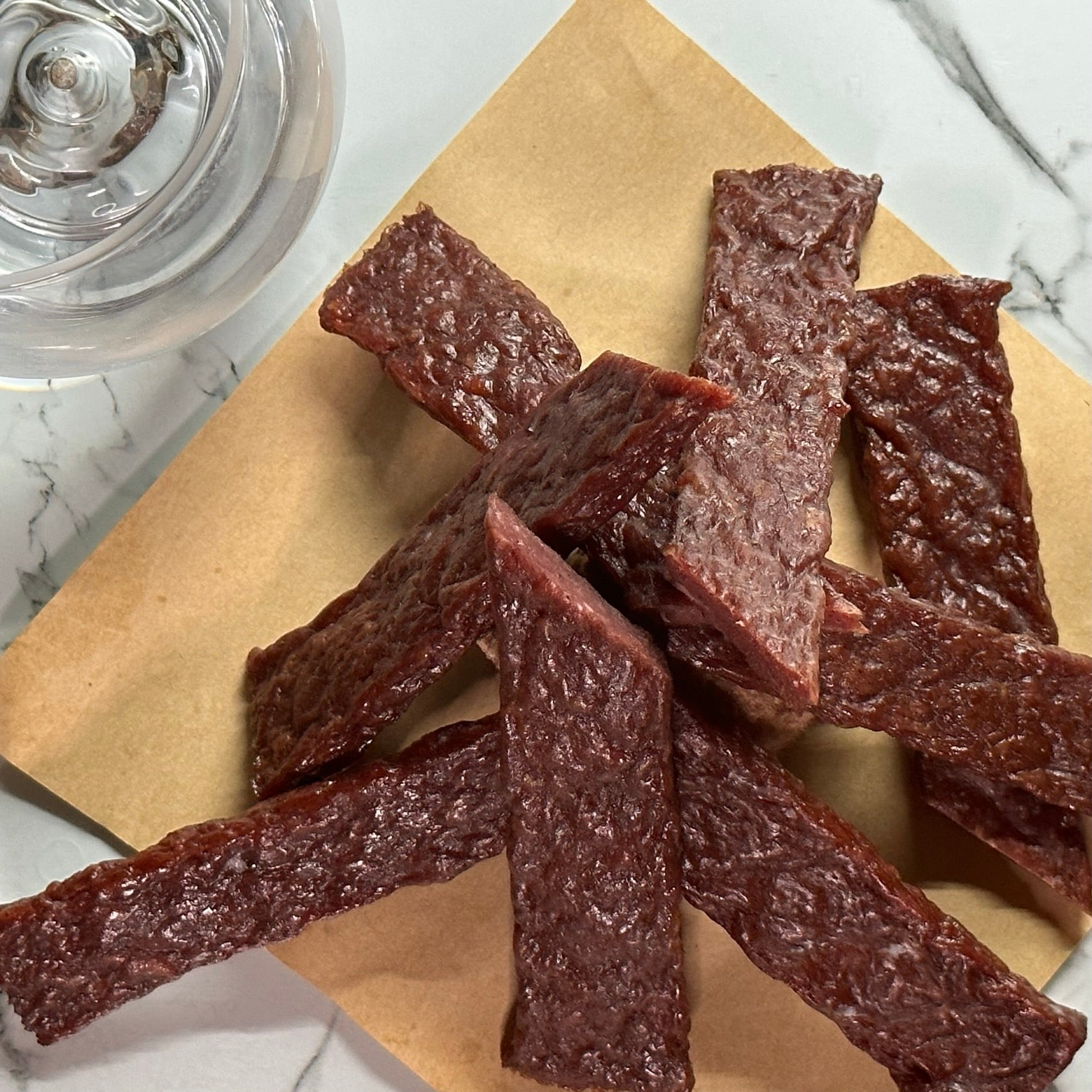 CUT PIECES OF GIN INFUSED JERKY STYLE STEAK STRIPS